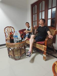 two men sitting in wicker chairs and a table at Hotel Suncity Villa in Trivandrum