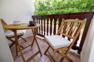 a table and two chairs on a balcony with a table and a table at Holiday Home Katja in Srpenica