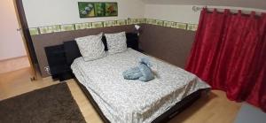 a bedroom with a bed with a teddy bear on it at House surrounded by creek in La Bresse