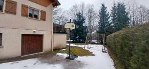 a basketball hoop in the snow in front of a house at House surrounded by creek in La Bresse