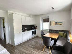 a kitchen and living room with a table and a couch at Appartement Marlene in Maishofen