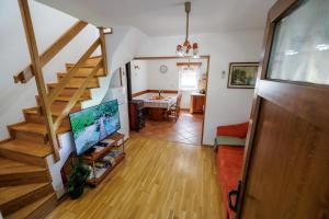 a living room with a staircase with a television at Holiday Home Katja in Srpenica
