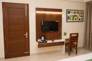 a room with a desk with a television and a door at Hotel IT Park Home Stay Near DLF City Centre Mall in Manī Mājra