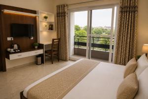 a hotel room with a bed and a balcony at Hotel IT Park Home Stay Near DLF City Centre Mall in Manī Mājra