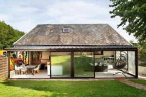 an extension to a house with sliding glass doors at Gîte Ressources - Jacuzzi in La Frenaye