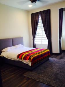 a bedroom with a bed with a rug and a window at Leong Homestay Kuantan in Kuantan