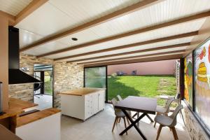 a kitchen and dining room with a table and chairs at Gîte Ressources - Jacuzzi in La Frenaye