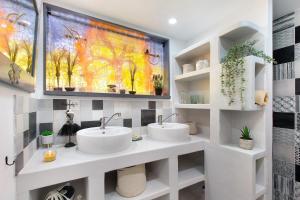 two sinks in a bathroom with a painting on the wall at Gîte Ressources - Jacuzzi in La Frenaye +29 photos
