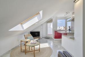 a kitchen and living room with a table and chairs at Ático Pedro Romero in Ronda