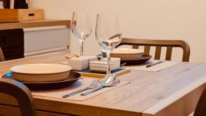 a table with two wine glasses and plates on it at Faraglioni Bay in Acitrezza