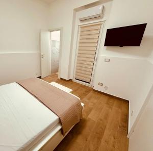 a bedroom with a bed and a flat screen tv at Faraglioni Bay in Acitrezza