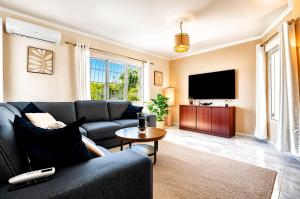 a living room with a couch and a tv at Villa de Golf Hoyo 19 in Busot