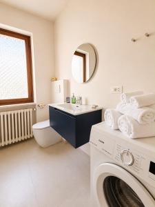 a bathroom with a sink and a washing machine at Giuditta Apartment in Ciriè