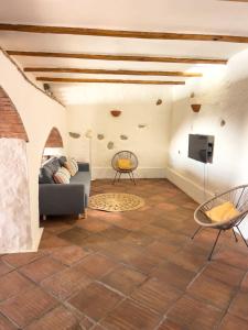 a living room with a couch and a tv at Palmeira Nature Lodge in Tavira