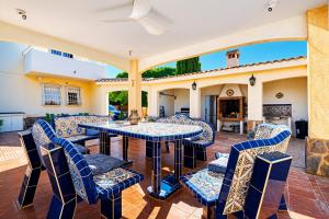 a patio with a table and chairs and a fireplace at Villa de Golf Hoyo 19 in Busot