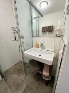 a white bathroom with a sink and a shower at Appartement Marlene in Maishofen +24 photos