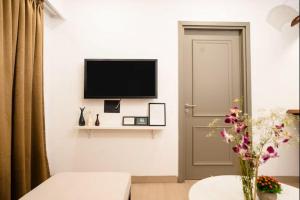 a living room with a television and a door at Calangute Heights in Calangute +5 photos