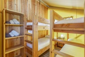 a room with three bunk beds in a cabin at Glamping - Quinta do Cascalhal in Arco de Baúlhe +129 photos