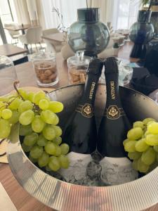 two bottles of wine in a bowl of grapes at Villa ArboreA in Squinzano