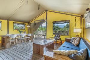 a living room with a couch and a table at Glamping - Quinta do Cascalhal in Arco de Baúlhe