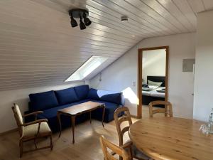 a living room with a blue couch and a table at Haus Hanni in Höchenschwand +24 photos