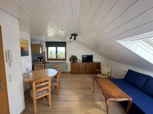 a living room with a table and a blue couch at Haus Hanni in Höchenschwand