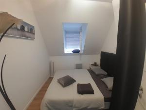 a small white room with a bed and a window at Haven Sierentz in Sierentz