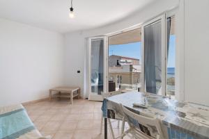 a dining room with a table and a view of the ocean at Casa Marea in Marzamemi