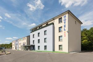 a white building with a sign on the side of it at Sure Hotel by Best Western Reims Nord in Reims
