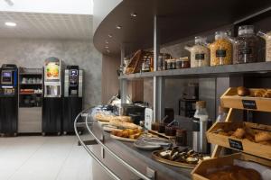 a bakery with a counter with bread and pastries at Sure Hotel by Best Western Reims Nord in Reims