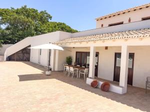 a house with a patio with an umbrella at Palmeira Nature Lodge in Tavira