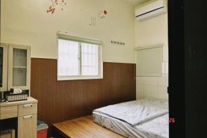 a bedroom with a bed and a window at Ajuan Homestay in Hengchun South Gate