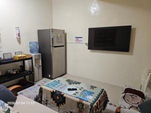 a living room with a refrigerator and a table in a room at Ajuan Homestay in Hengchun South Gate