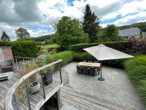 a patio with a table and an umbrella at Authentique gite de village in Hotton