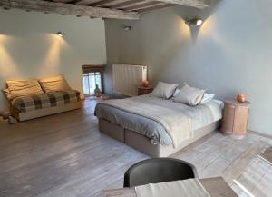 a bedroom with a large bed and a couch at Authentique gite de village in Hotton