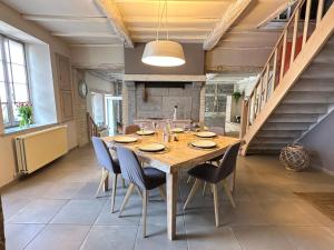 a large dining room with a wooden table and chairs at Authentique gite de village in Hotton