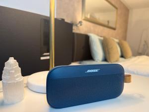 a blue speaker sitting on a table in front of a bedroom at THE PANAMERICANA, Air-Conditioned, 4K HD TV, Bose, Lounge in Riedstadt
