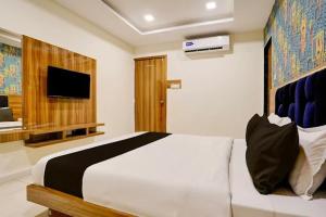 a bedroom with a large bed and a television at Hotel Lakeview Vadodara in Vadodara +18 photos