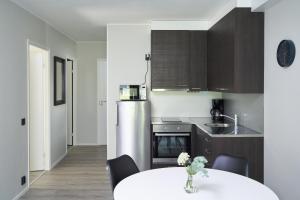 a kitchen with a white table and a refrigerator at Naantali City Apartments in Naantali