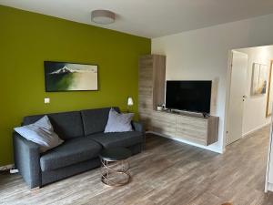 a living room with a couch and a flat screen tv at Appartement Marlene in Maishofen
