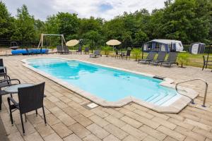 a large swimming pool with chairs and a playground at Holstebro Søpark in Holstebro