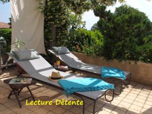 a patio set with two chairs and a hat at Une Heure Bleue in Manosque