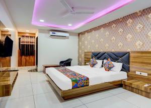 a hotel room with a bed and a tv at Hotel Lakeview Vadodara in Vadodara