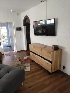 a living room with a flat screen tv on a wall at Lucys Bungalow in Butjadingen