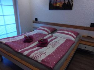 a bed with red and white pillows on it at Lucys Bungalow in Butjadingen