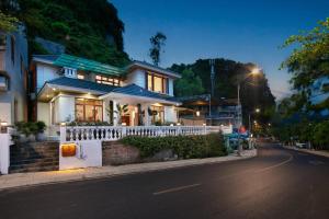 a white house with a fence on the side of a street at Maison Bay View Villa Cat Ba in Ðồng Khê Sâu