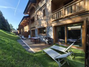 a house with a deck with a table and chairs at Gervonne 2 in Morzine