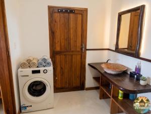 a bathroom with a washing machine and a sink at Consul's House Vilanculos in Vilanculos