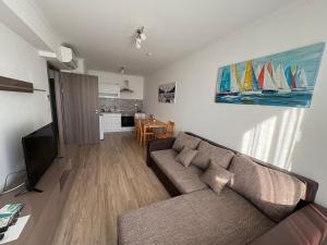 a living room with a couch and a television at Seaforth Apartment in Siófok