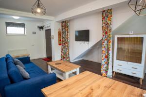 a living room with a blue couch and a table at Barrique 24-4 - Breakfast delivered & Minibar - Free Parking -Officially classified guesthouse in Braşov